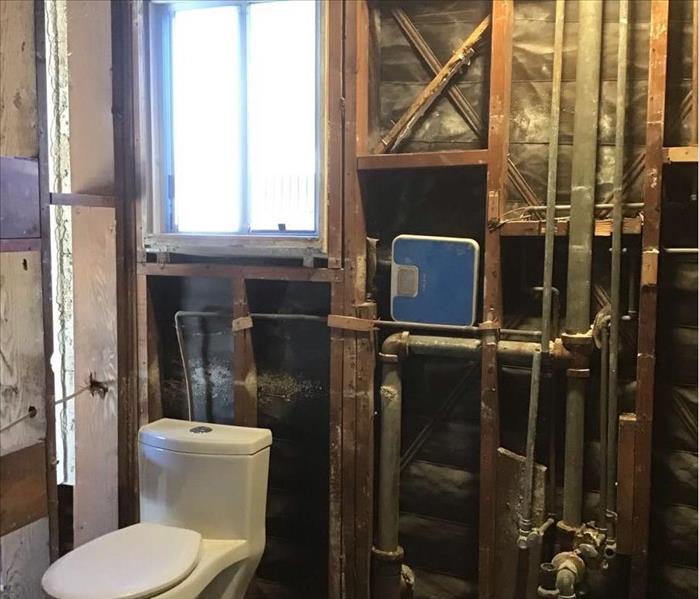 bathroom with walls stripped exposing pipes and inner structure