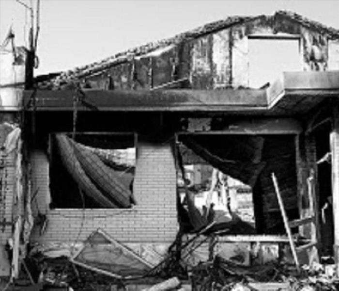 Black and white photo of a fire damaged home