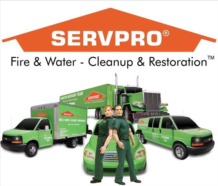 Servpro technicians back to back in front of green servpro truck